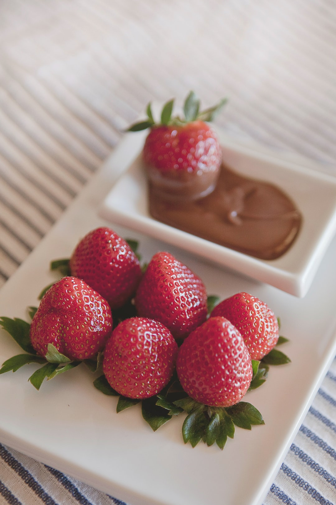 Fresh strawberries canned for preservation on wooden surface.