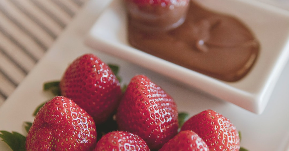 Fresh strawberries canned for preservation on wooden surface.