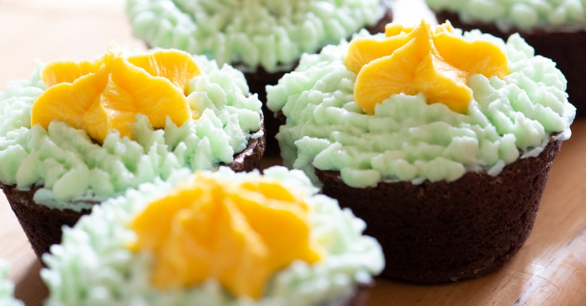 Green tea cupcakes with frosting on a white plate.