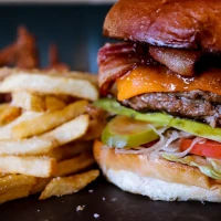 Bacon press in action flattening bacon for perfect crispiness. Bacon press in action flattening bacon for perfect crispiness.