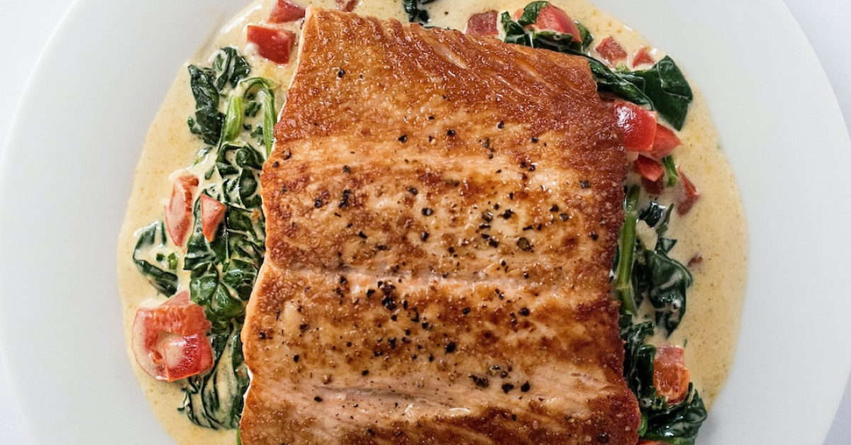 Quiche Florentine on plate with spinach and feta toppings.