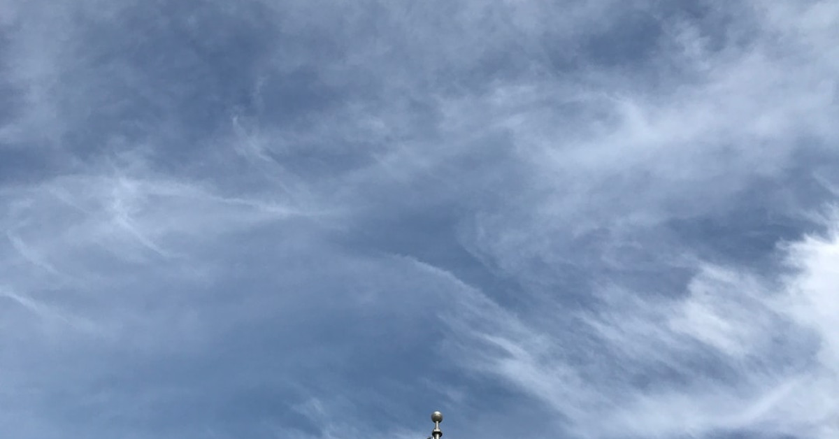 Hiker with LEKI poles on scenic mountain trail.