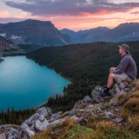 Trekker with chest rig navigating forest trail guide cover. Trekker with chest rig navigating forest trail guide cover.