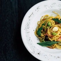 Gourmet bacon pasta with vegetables on plate. Gourmet bacon pasta with vegetables on plate.