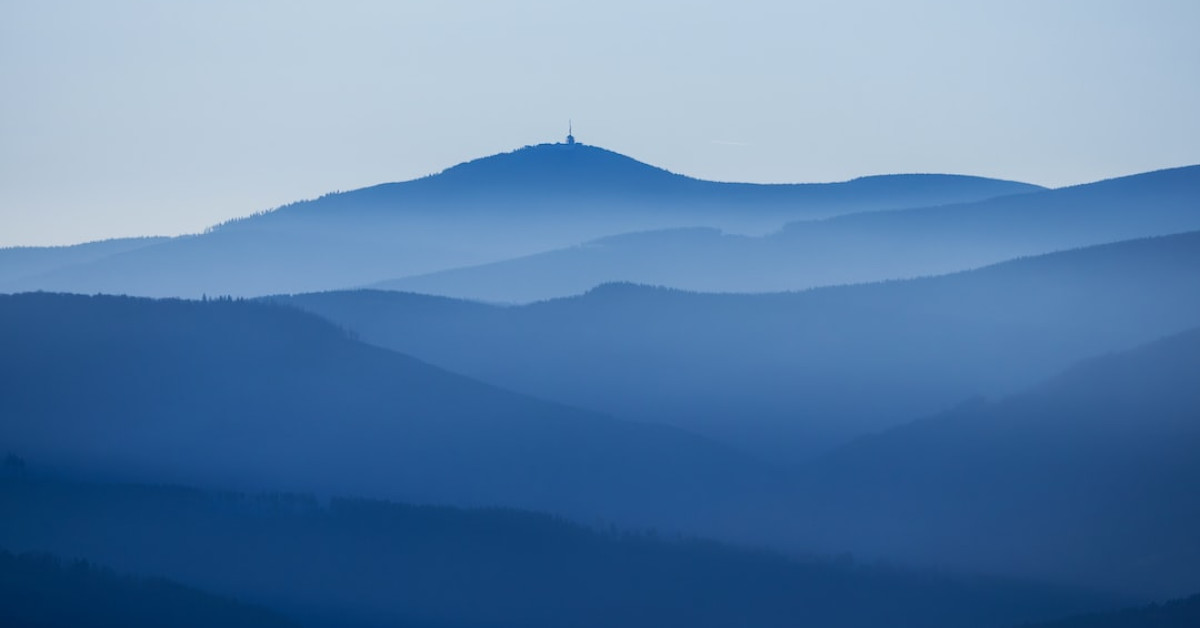 Blue Stanley cup held aloft, celebrating coffee traditions.