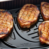Air-fried thick pork chops on a plate. Air-fried thick pork chops on a plate.