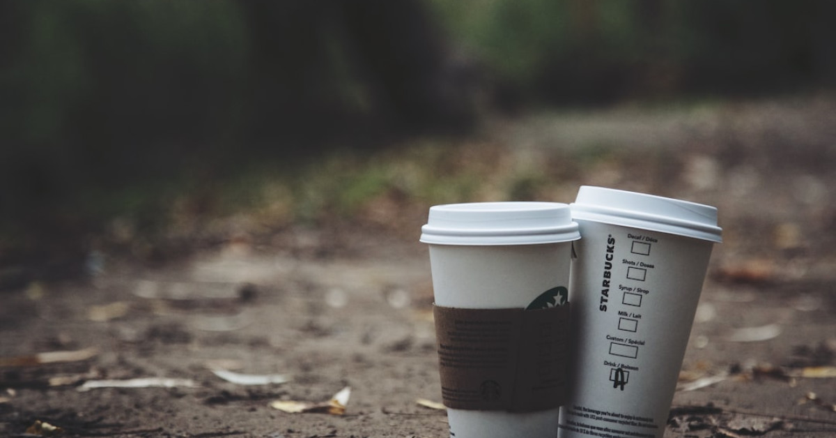 Starbucks autumn-themed cups on wooden table.