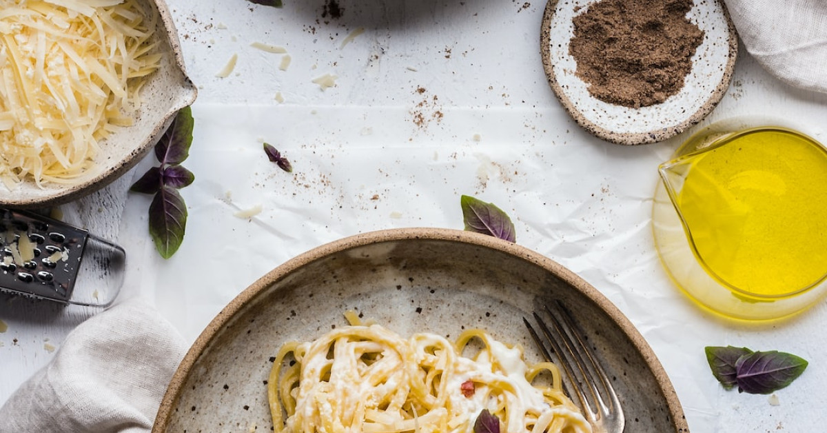 Stracciatella pasta with fresh vegetables on white plate