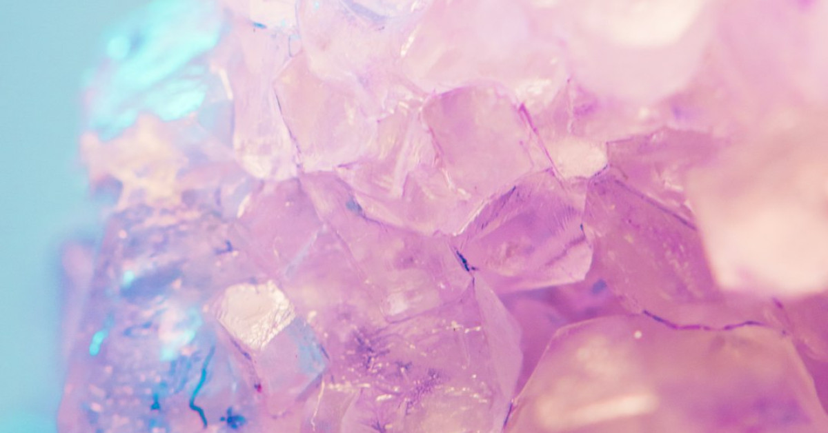 Modern groom in blue suit with purple wedding theme details.