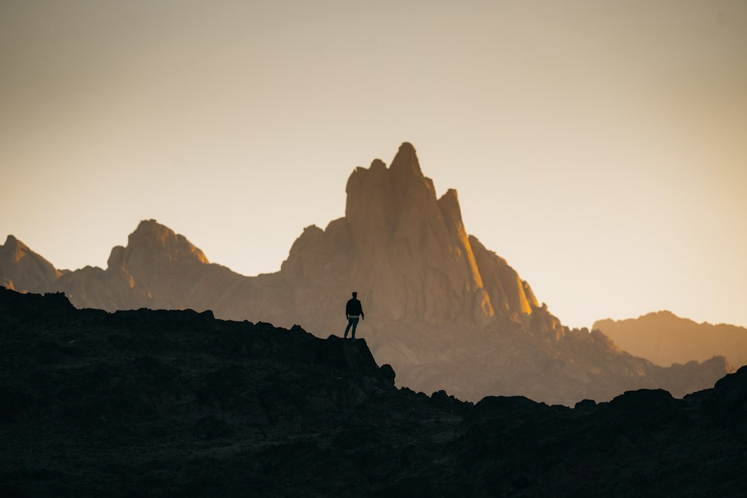 Hikers' silhouette at twilight on mountain trekking adventure.