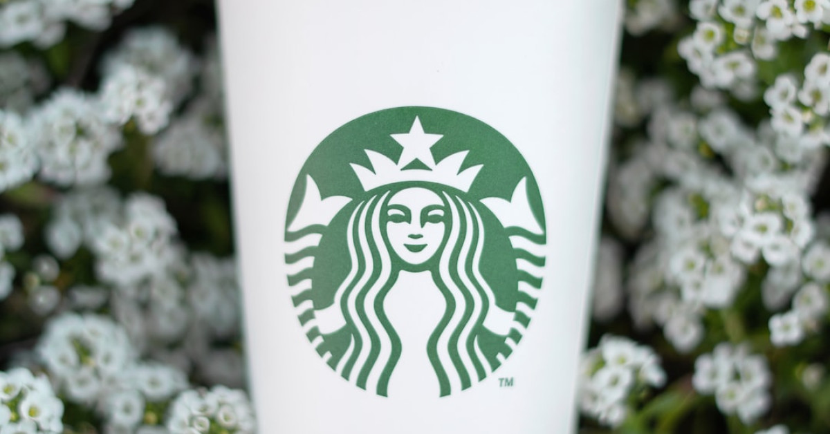 Starbucks blue coffee cup with secret elegance guide.