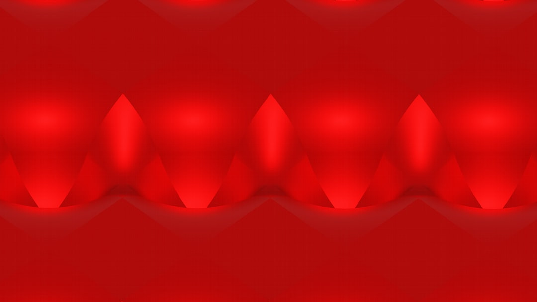 Costco Red Bull cans next to coffee mug on table.