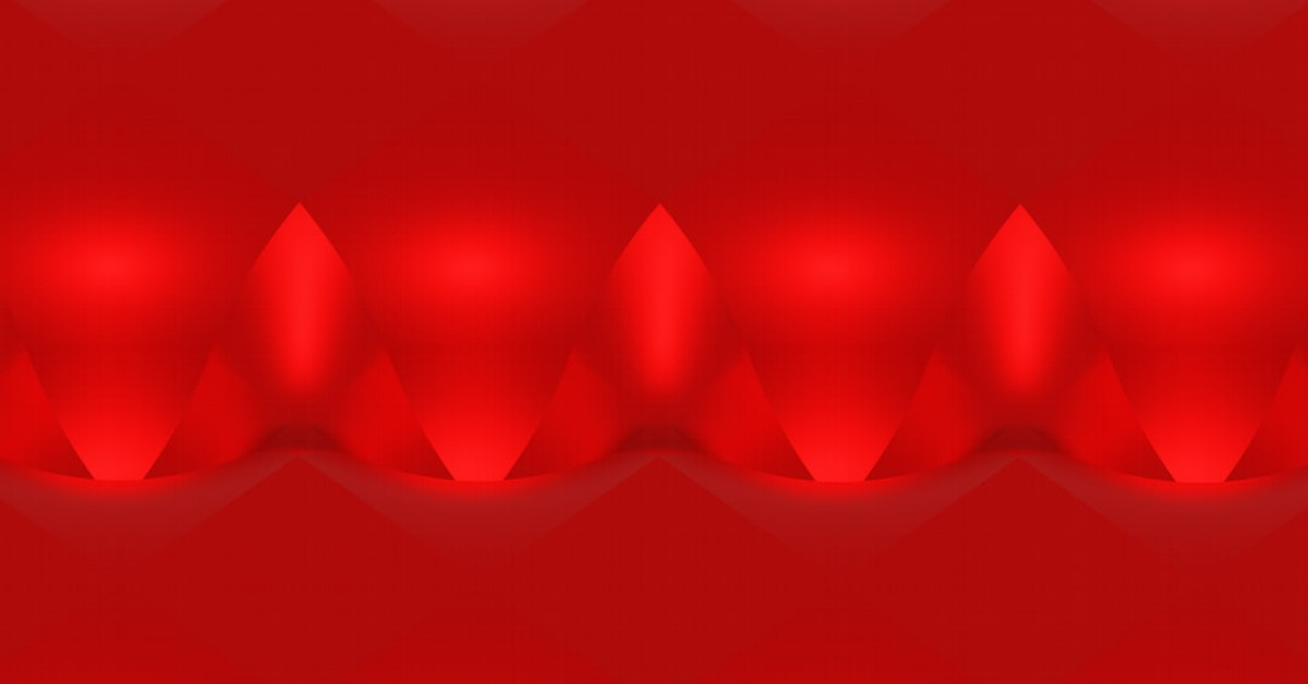 Costco Red Bull cans next to coffee mug on table.